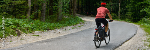 Man cyclist goes on the road in forest