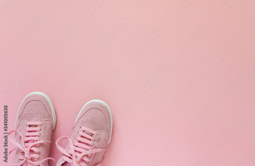 Pink nubuck sneakers isolated on a pink background, seasonal shoes for walking and sports, top view