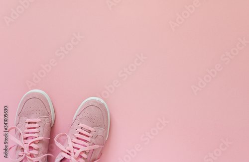 Pink nubuck sneakers isolated on a pink background, seasonal shoes for walking and sports, top view