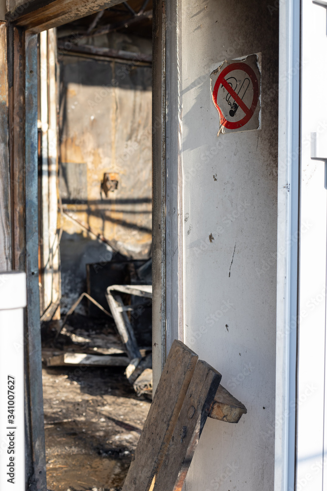 No smoking sign near the door of a room burnt from a fire. consequences of a fire. side view. vertical image. selective focus.