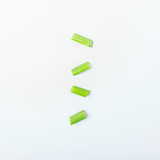 Sliced ​​pieces of fresh green celery stalk on a white background
