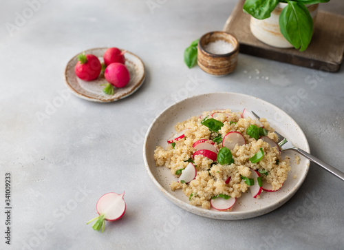 tasty vegetarian salad with quinoa, fresh radish and basil on a gray concrete background. Super food and healthy eating concept. horizontal image. place for text.