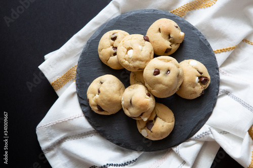 Closeup Of Chocolate Chip Cookies On Slate Platter With Black Background