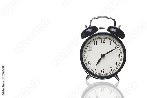 black alarm clock isolated on a white background, space for text on the left