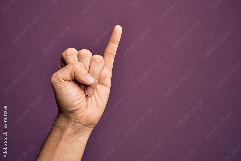 Hand of caucasian young man showing fingers over isolated purple background showing little finger as pinky promise commitment, number one