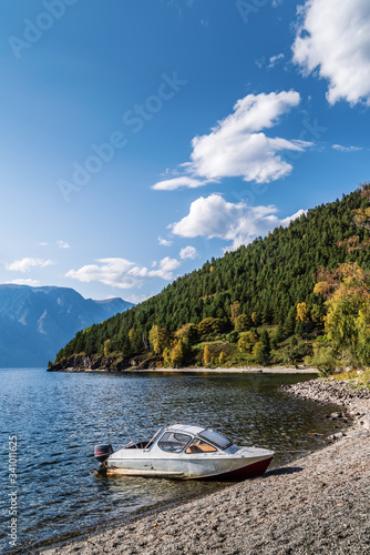 Motor boat moored to the shore of a mountain lake. Russia, Altai Republic, Ulagansky district, Lake Teletskoye, tract Cordon Chiri photo