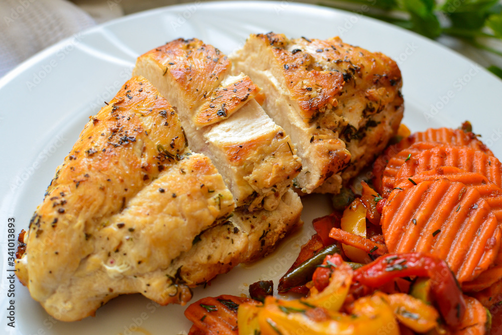 Baked chicken breast with vegetable. Light background. Close up. Meat dish. Food in a white plate. Healthy lunch.
