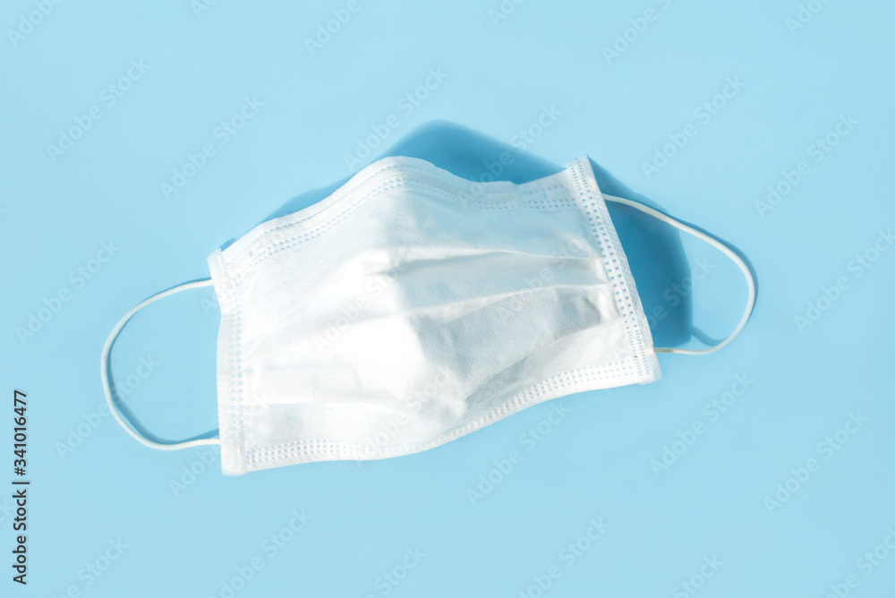 Disposable medical mask on blue background. Healthcare and medical concept. Disposable medical mask on blue background. Healthcare and medical concept.