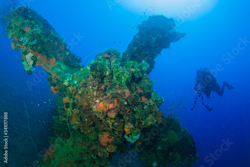 A diver observes the impressive propeller of the sunken ship Heian Maru. This vessel was a second world war Japanese ship that was sunk in Chuuk Lagoon during conflict