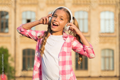 Learning concept. Home schooling online education. Smiling schoolgirl. Wherever i go. Back to school. Small girl in headphones. Listening audio book. Free ebook. Girl in headphones listening music