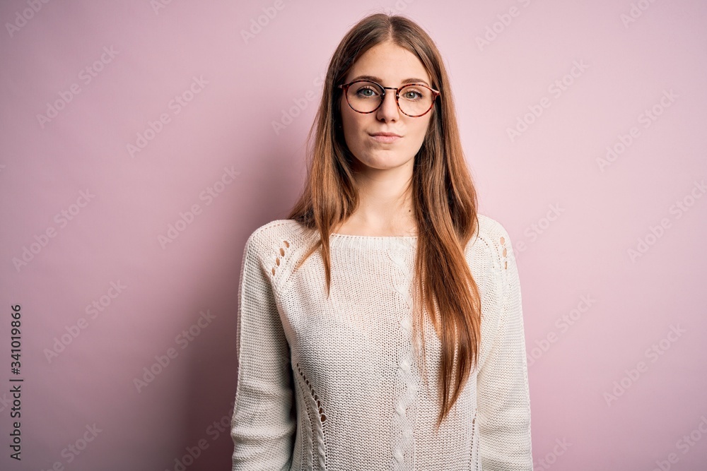 Young beautiful redhead woman wearing casual sweater and glasses over pink background looking sleepy and tired, exhausted for fatigue and hangover, lazy eyes in the morning. Young beautiful redhead woman wearing casual sweater and glasses over pink background looking sleepy and tired, exhausted for fatigue and hangover, lazy eyes in the morning.