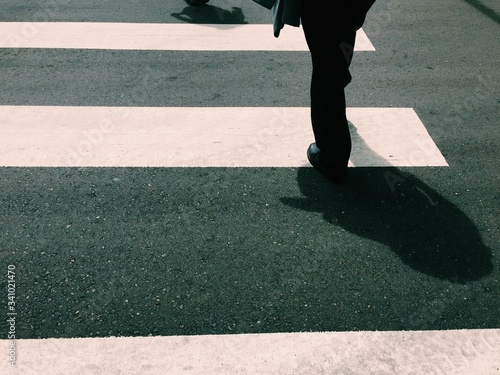 Fotografia Low Section Of Person Walking On Zebra Crossing At Street