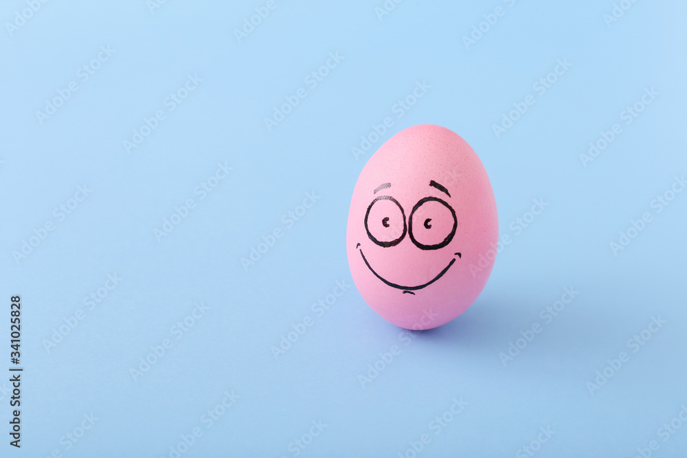 Funny pink egg with face feeling on blue background