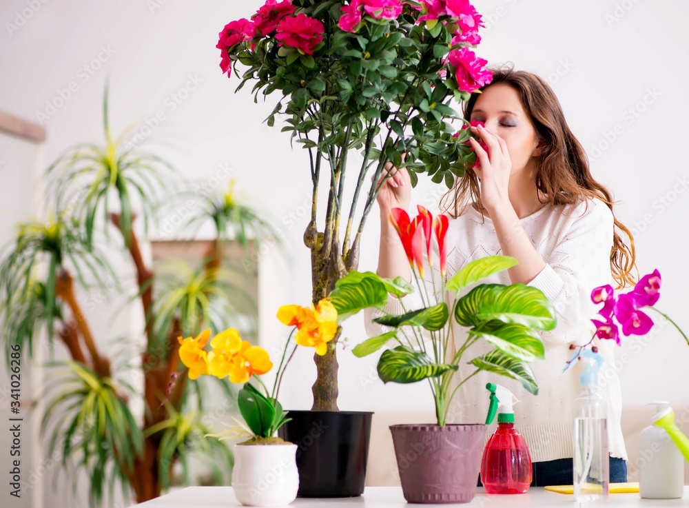 Young woman looking after plants at home Young woman looking after plants at home
