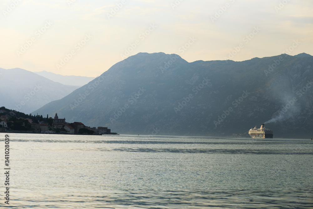 Large liner on the horizon of the Bay of Kotor. Scenic view of the sea and mountains