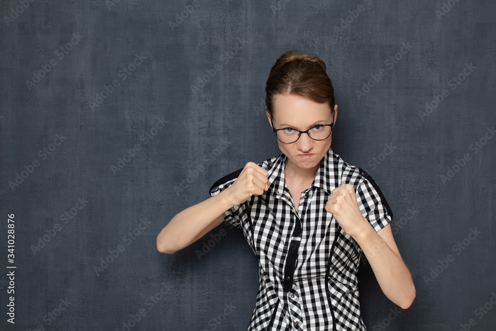 Portrait of angry dissatisfied girl holding fists in front of her Portrait of angry dissatisfied girl holding fists in front of her