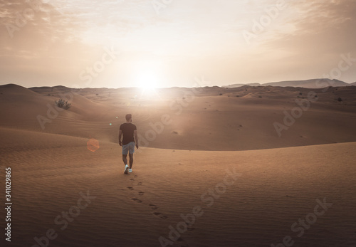 Junger Mann genießt Sonnenaufgang in der Wüste © weixx