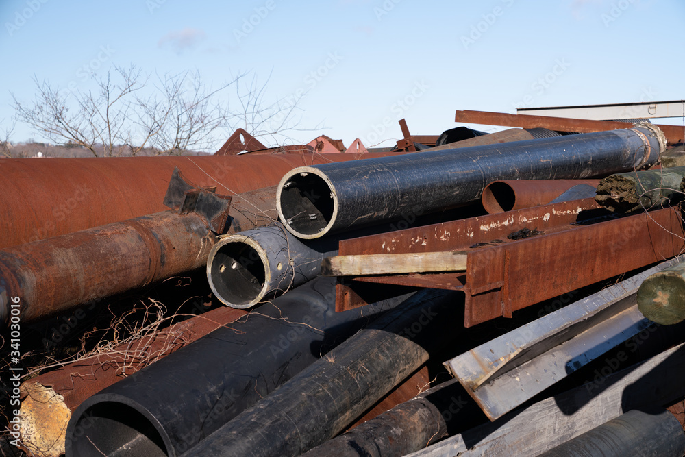 Pile of scrap metal and metal tubes rusting outside