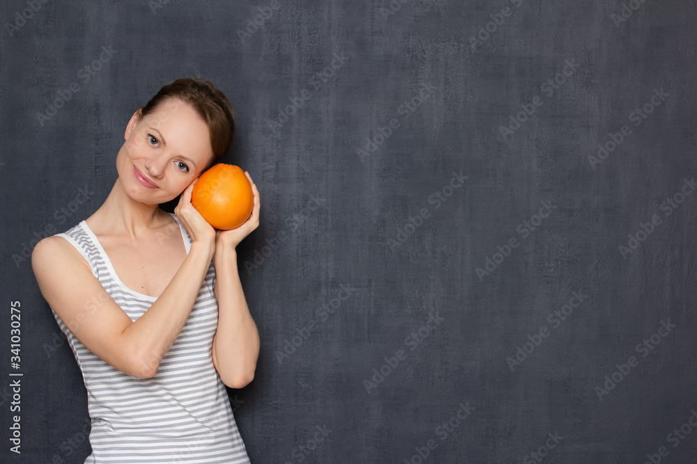 Portrait of happy girl holding ripe grapefruit in hands and smiling Portrait of happy girl holding ripe grapefruit in hands and smiling