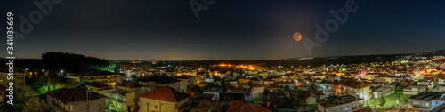 Panoramic night photo with the full moon in the background. At Polykastro in Greece photo