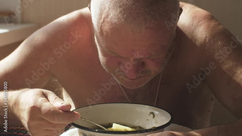 Rural man eating soup at home photo