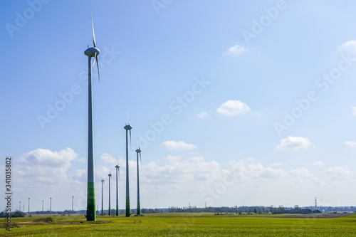 wind farm in a green field on a background of blue sky