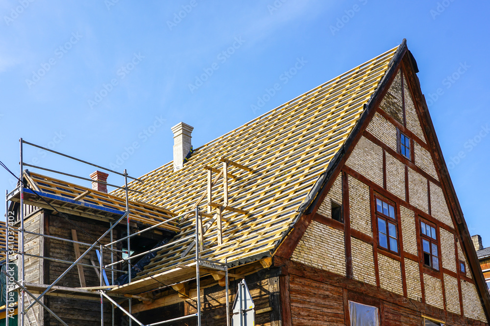 repair of the roof structures of a historic wooden house and replacement of clay tiles