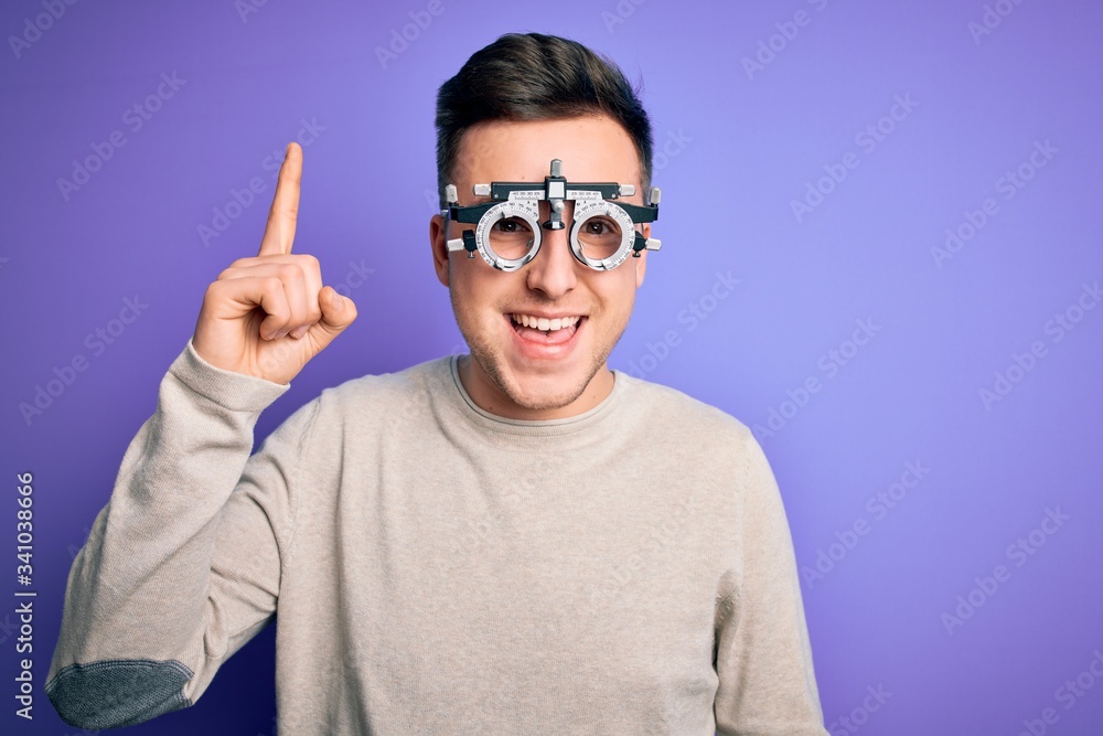 Young handsome caucasian man wearing optometrical glasses over purple background pointing finger up with successful idea. Exited and happy. Number one. Young handsome caucasian man wearing optometrical glasses over purple background pointing finger up with successful idea. Exited and happy. Number one.