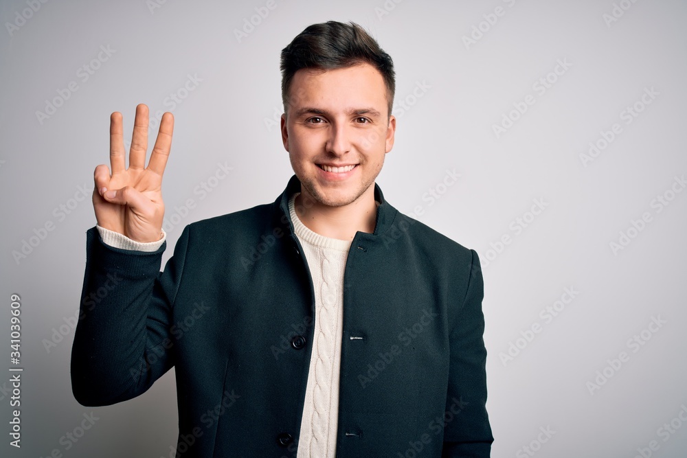 Young handsome business mas wearing elegant winter coat standing over isolated background showing and pointing up with fingers number three while smiling confident and happy. Young handsome business mas wearing elegant winter coat standing over isolated background showing and pointing up with fingers number three while smiling confident and happy.