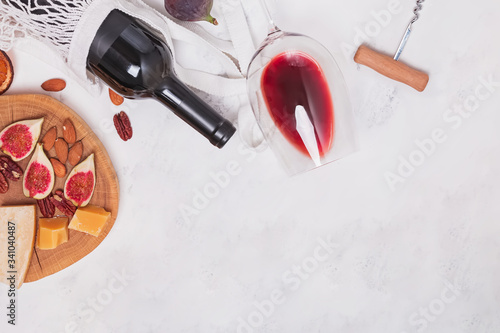 Flat lay composition with bottle and glass of red wine and different snacks
