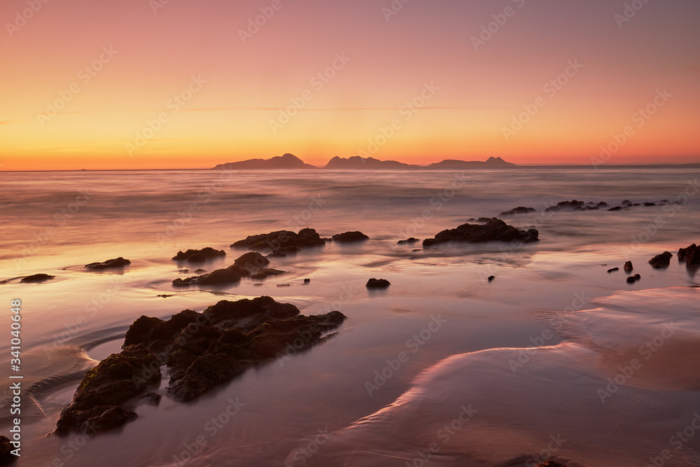 Sunset on the beach of Patos with the silhouette of the Cies islands in the background.