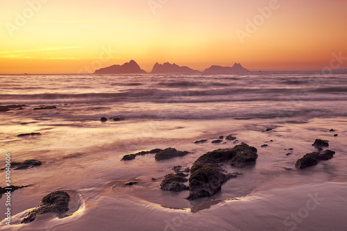 Sunset on the beach of Patos with the silhouette of the Cies islands in the background.