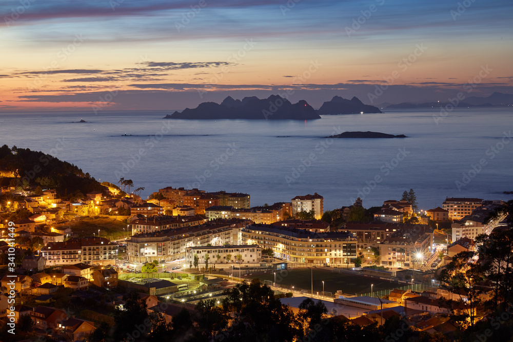 Sunset view of the city of Baiona with the silhouette in the background of the Cies islands in Galicia, Spain.