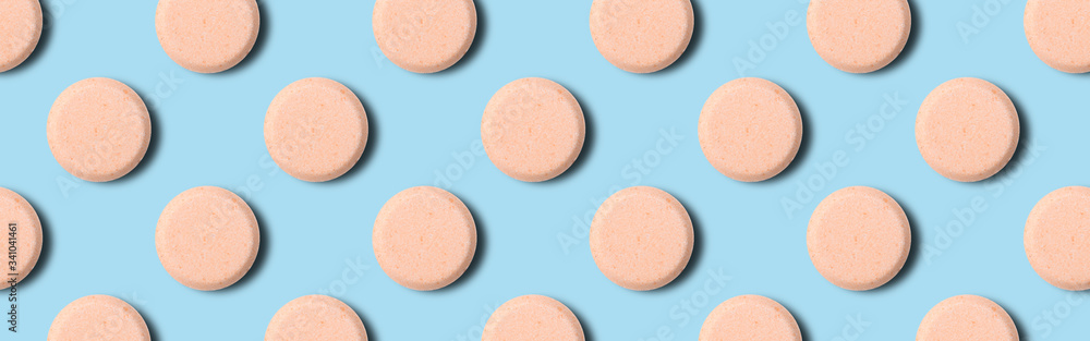 Seamless pattern of pharmaceutical pills or vitamins on a blue background. Orange pills on a blue background. Seamless pattern of pharmaceutical pills or vitamins on a blue background. Orange pills on a blue background.