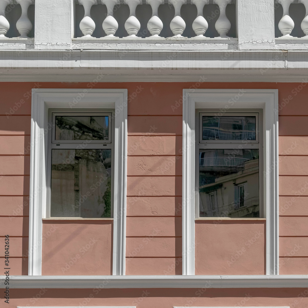 Fototapeta premium modern interpratation of classic building design with pink wall and white frame openings