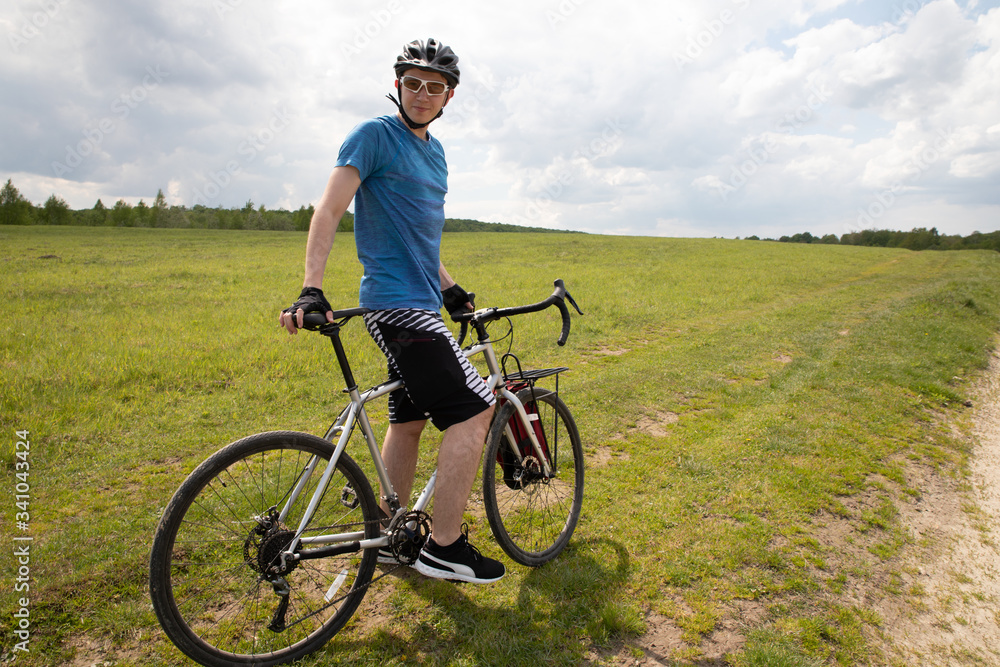 Man with bicycle in full cycling equipment in green summer field, active healthy lifestyle in nature envirment Man with bicycle in full cycling equipment in green summer field, active healthy lifestyle in nature envirment
