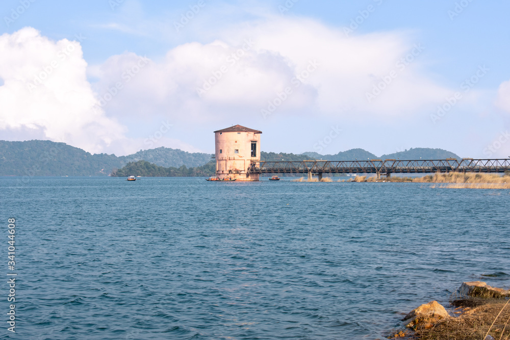 a pump house in the middle of the maithon lake with beautiful clouds