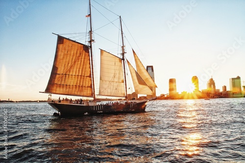 Sailing ship during city sunset 