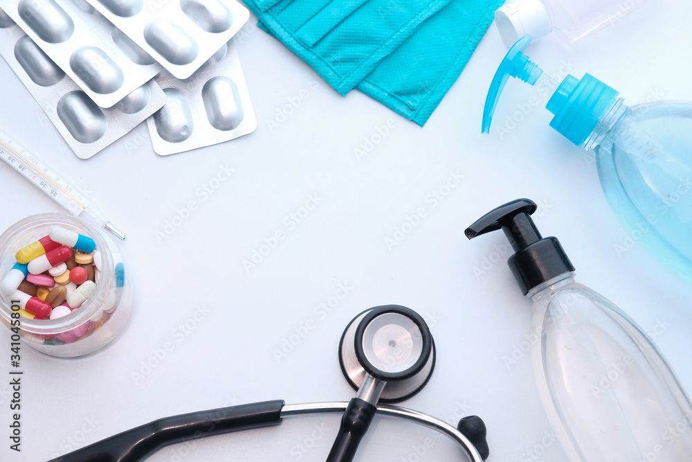 hand sanitizer, mask, stethoscope and pills on white hand sanitizer, mask, stethoscope and pills on white