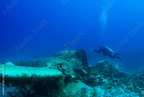 A scuba diver exploring an underwater sunken plane called the Betty Bomber in Chuuk Lagoon. The Japanese aircraft was destroyed in operation hailstone during the second world war