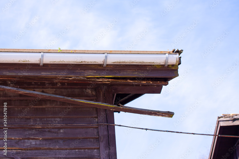 Rotten wood on top of old wooden building. Timber board falling off. Rotten wood on top of old wooden building. Timber board falling off.