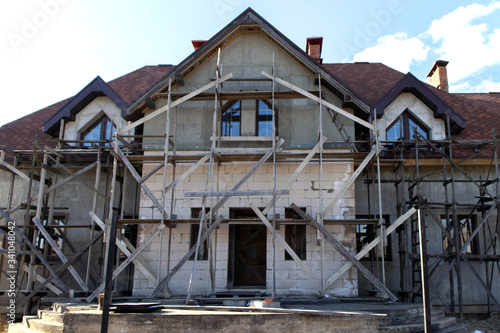 Unfinished residential home in construction progress at building site © Yekatseryna