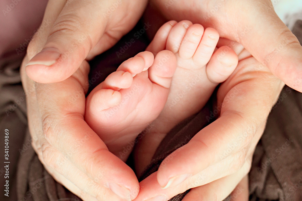 Baby legs of a newborn baby in mom’s hands, macro shot. Mom and her baby. Maternity. The concept of a happy family. Beautiful conceptual image of motherhood. Mothers Day. Baby legs of a newborn baby in mom’s hands, macro shot. Mom and her baby. Maternity. The concept of a happy family. Beautiful conceptual image of motherhood. Mothers Day.