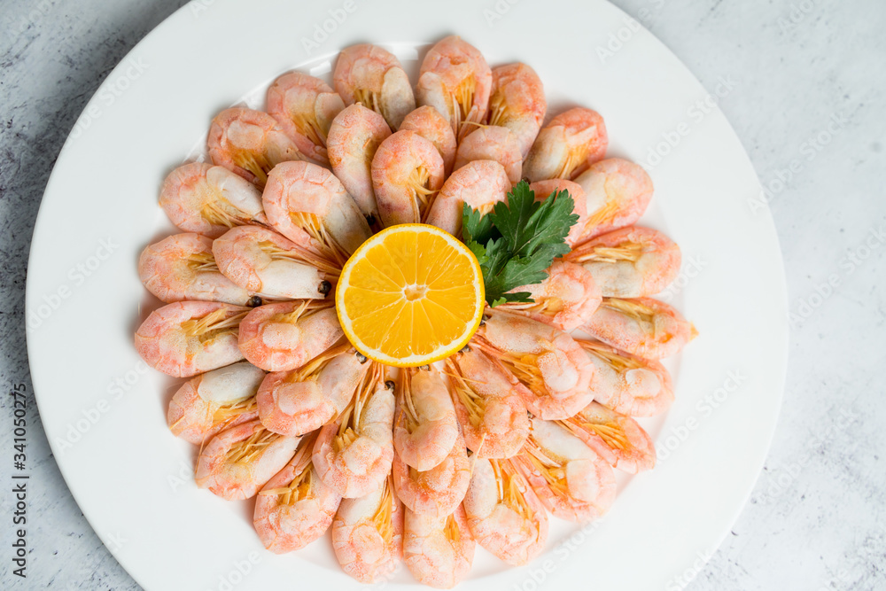 Large plate with boiled shrimps served with lemon