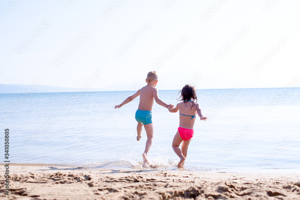 Kids holding hands and jumping into the sea