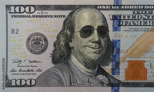 Happy smiling president Franklin portrait wearing sunglasses on 100 dollar bill. Concept of economic growth