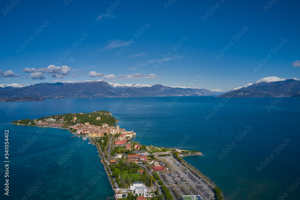 Sirmione town, Lake Garda, Italy. Aerial view of Sirmione Castle. The historical part of the city.  In the background mountains in the snow and blue sky