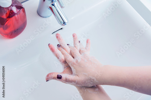 Frau benutzen Seife um Händewaschen unter dem Wasserhahn. Hygienekonzept Hand Detail.cor