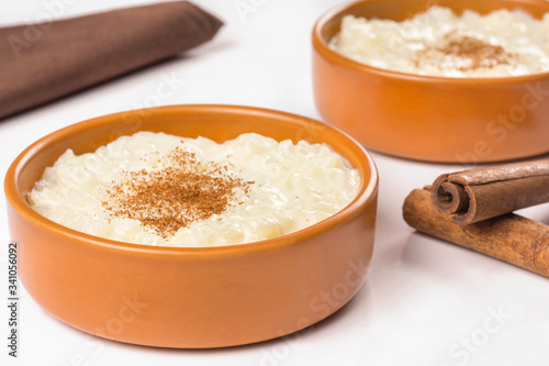 Traditional June party Brazilian dessert made of rice and condensed milk called arroz doce in white background close
