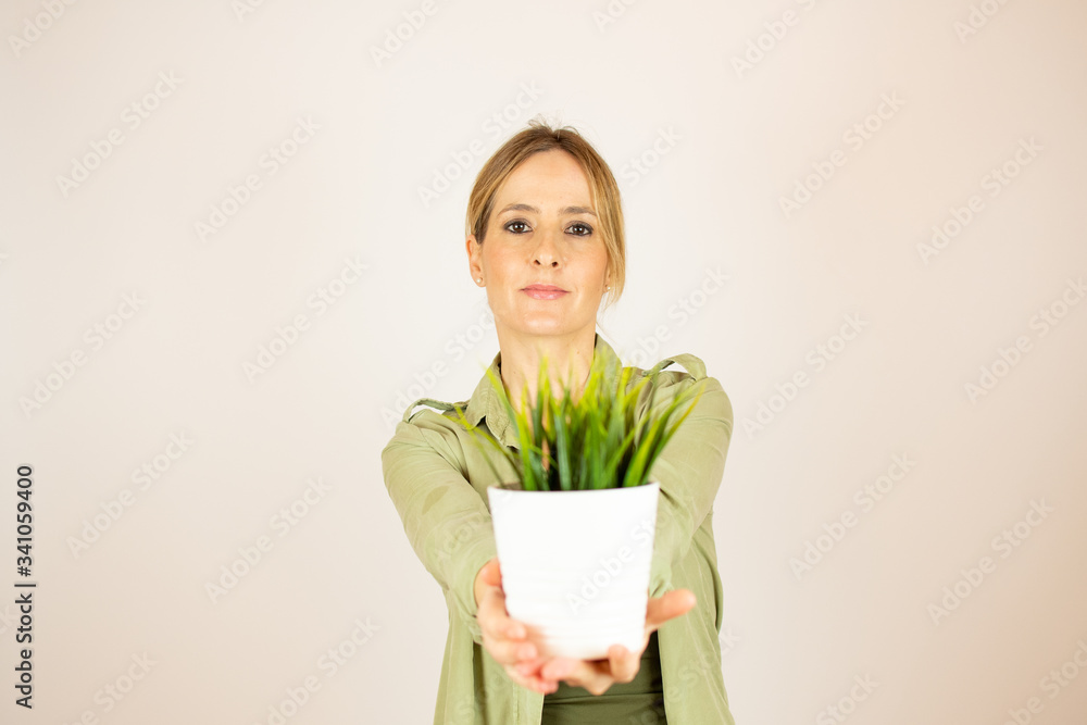Beautiful woman showing a plant in her hand Beautiful woman showing a plant in her hand